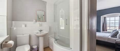A bathroom with a toilet, sink, and shower.