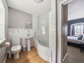 Et badeværelse med toilet, vask og bruser.