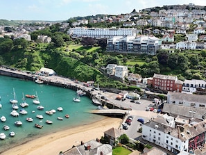 Une ville côtière dotée d’un port de plaisance, d’une plage de sable et d’immeubles résidentiels.