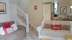 Ein Wohnzimmer mit zwei Sofas, einem Holztisch und einer Treppe.
