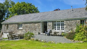 A stone building with a sloped roof, a gravel driveway, and outdoor seating. - 3 bedroom accommodation in Advent (Advent)