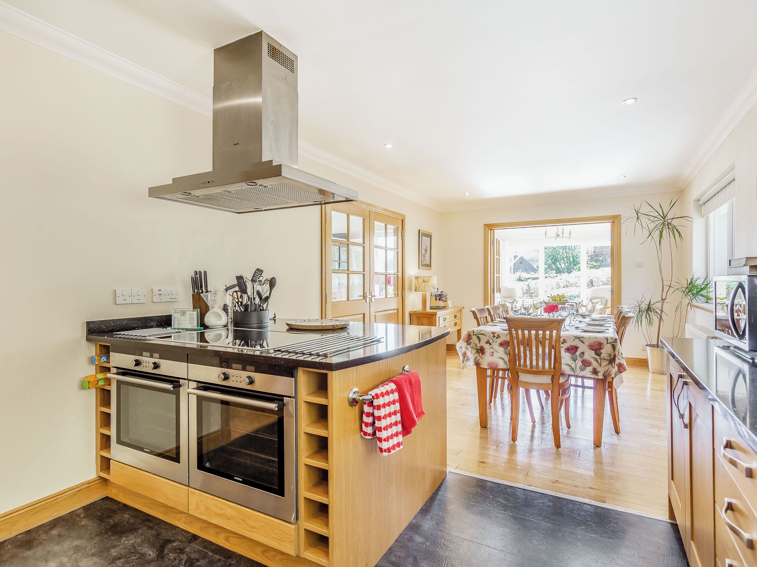 A modern kitchen with an oven, a stove, and a stainless steel range hood.