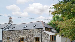 A stone house with a sloped roof, two windows, and a door. - 3 bedroom accommodation in St Gennys, Bude (St Gennys, Bude)
