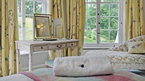 Une chambre à coucher avec un lit, une table de chevet avec un miroir et des rideaux.