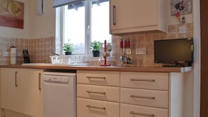 Une cuisine moderne équipée d’un lave-vaisselle, d’un plan de travail et de placards.