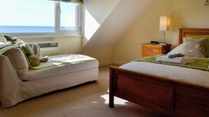 A bedroom with a bed, a sofa, a nightstand, and a window with a view. - 1 bedroom accommodation in Llanaber, near Barmouth (Llanaber, near Barmouth)