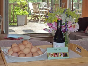 A table with a bowl of eggs, a wine bottle, and a welcome card.