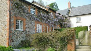 A stone building with multiple windows and a wooden gate. - Cider Cottage - E5576 (Chittlehampton, near Umberleigh)