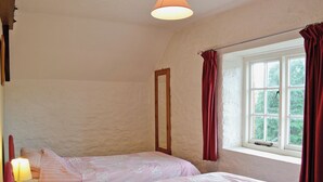 A bedroom with two beds, a window with curtains, and a lamp. - Cider Cottage - E5576 (Chittlehampton, near Umberleigh)