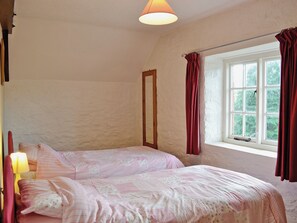 A bedroom with two beds, a window with curtains, and a lamp. - Cider Cottage - E5576 (Chittlehampton, near Umberleigh)