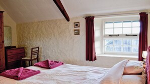 A bedroom with a bed, a chair, a dresser, and a window with curtains. - Cider Cottage - E5576 (Chittlehampton, near Umberleigh)