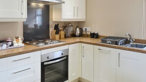 Eine moderne Küche mit weißen Schränken, Edelstahlgeräten und einer Holz Arbeitsplatte.