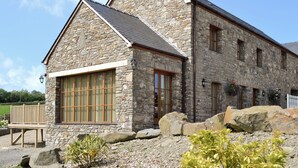 A stone building with large windows and a sloped roof. - 4 bedroom accommodation in Mydroilyn, near Aberaeron (Mydroilyn, near Aberaeron)