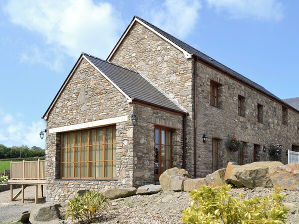 A stone building with large windows and a sloped roof.