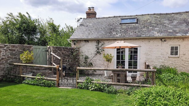 A rustic stone house with a wooden deck and a small garden. - 1 bedroom accommodation in Combe, near Presteigne (Combe, near Presteigne)