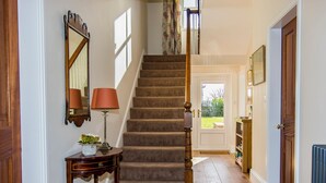 A staircase with carpeted steps leading to a door with a view of a garden.