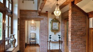 A hallway with a wooden floor, a patterned rug, a vintage clock, and a chair. - 4 bedroom accommodation in Webbery, near Bideford (Webbery, near Bideford)