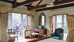 A bedroom with a bed, a desk, two chairs, a dresser, and a large mirror. - 4 bedroom accommodation in Webbery, near Bideford (Webbery, near Bideford)