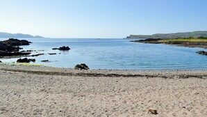 A coastal landscape with a sandy beach, calm sea, and distant hills. - 4 bedroom accommodation in Millport, Isle of Cumbrae (Millport, Isle of Cumbrae)