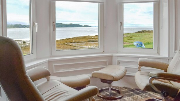 A room with three large windows offering a view of a coastal landscape. - 4 bedroom accommodation in Millport, Isle of Cumbrae (Millport, Isle of Cumbrae)
