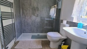Une salle de bain moderne équipée d’une douche, de toilettes et d’un lavabo.