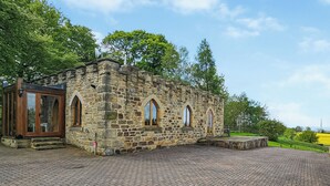 A stone building with arched windows and a brick-paved courtyard.