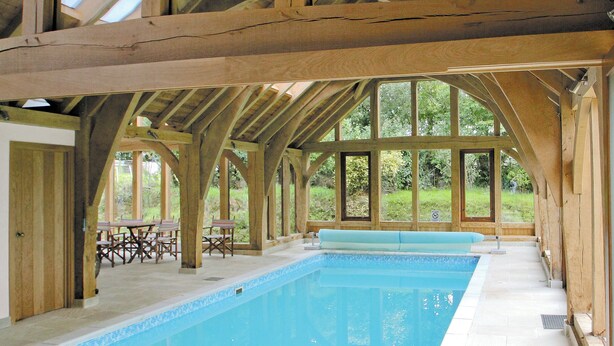 A large indoor swimming pool with a wooden ceiling and large windows. - Barfield's Cherry Tree Cottage (Canworthy Water, near Crackington Haven)