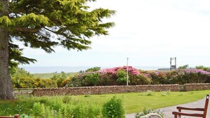 A bench and a stone wall with a view of the sea.