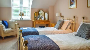 A bedroom with two beds, a dresser, a chair, and a window with blinds. - 2 bedroom accommodation in Whitby (Whitby)