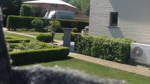 A building with "B&B" signage, surrounded by well-maintained hedges and a clear sky. - B&B Silentium (Tielt-Winge)