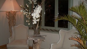A room with two chairs, a lamp, and a vase with flowers. - B&B Silentium (Tielt-Winge)