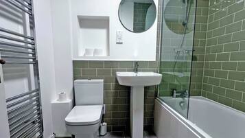 A bathroom with a toilet, sink, and shower.