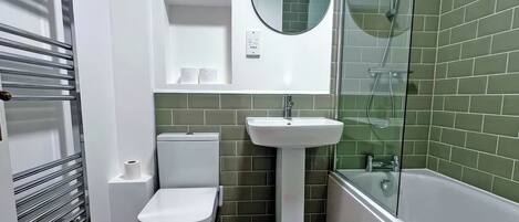 Een badkamer met toilet, wastafel en douche.