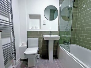 A bathroom with a toilet, sink, and shower.