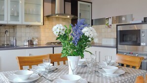 A modern kitchen with a dining table set for four, featuring a polka dot tablecloth, white plates, and clear glassware. - 3 bedroom accommodation in Milfield, near Wooler (Milfield, near Wooler)