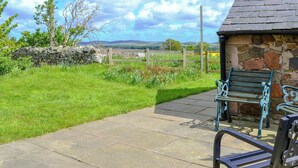 A stone building with a tiled patio and a bench. - 3 bedroom accommodation in Milfield, near Wooler (Milfield, near Wooler)