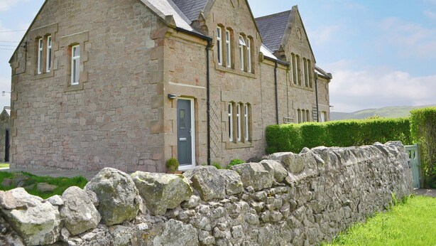 A stone building with a traditional architectural style, featuring a prominent entrance and multiple windows. - 3 bedroom accommodation in Milfield, near Wooler (Milfield, near Wooler)