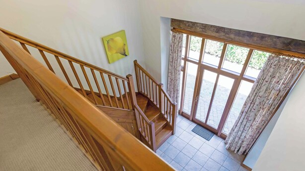 Een houten trap die leidt naar een balkon met uitzicht op het landschap.