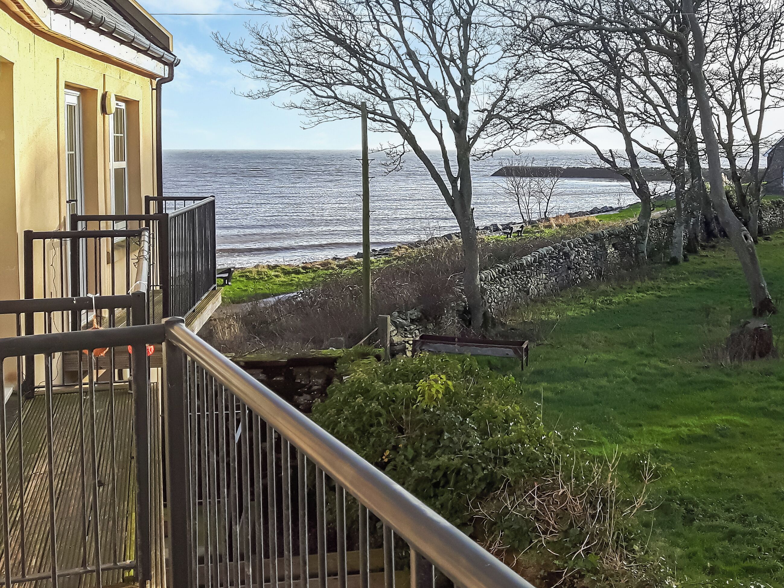 Ein Küstengebäude mit einem Balkon mit Blick auf das Meer.