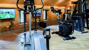A gym with various exercise equipment, a television mounted on the wall, and wooden flooring. - 0 bedroom accommodation in Glaisdale, near Whitby (Glaisdale, near Whitby)
