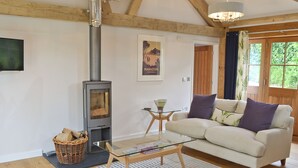 A cozy living room with a modern fireplace, a comfortable sofa, and a glass coffee table.