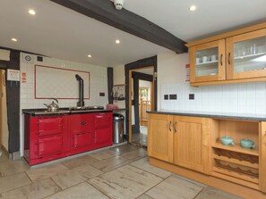 A kitchen with a red stove, wooden cabinets, and a tiled backsplash. - Parker’s dates from 1610 and is part of the 700-acre Netherley Hall Estate. (Mathon, near Malvern)