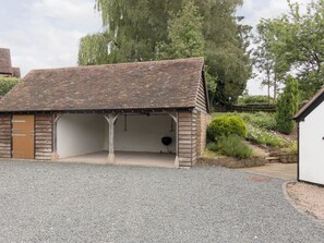 A small, single-story building with a sloped roof, a wooden door, and a gravel driveway. - Parker’s dates from 1610 and is part of the 700-acre Netherley Hall Estate. (Mathon, near Malvern)