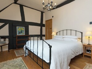 A bedroom with a four-poster bed, a wooden chair, a painting, a chandelier, and a nightstand with a lamp. - Parker’s dates from 1610 and is part of the 700-acre Netherley Hall Estate. (Mathon, near Malvern)