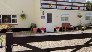 A two-story building with a sign indicating self-catering services. - 2 bedroom accommodation in Pen-y-Sarn, near Amlwch (Pen-y-Sarn, near Amlwch)