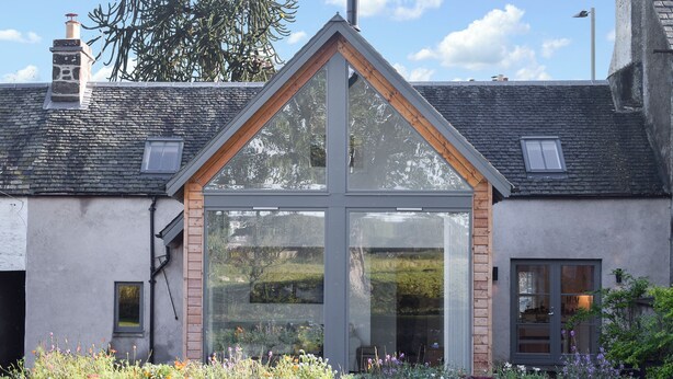 A modern building with a large glass window, a sloped roof, and a brick facade. - 3 bedroom accommodation in Muthill, near Crieff (Muthill, near Crieff)