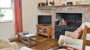 A cozy living room with a television, fireplace, and comfortable seating.