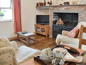 A cozy living room with a television, fireplace, and comfortable seating. - 2 bedroom accommodation in Bontnewydd, Caernarfon (Bontnewydd, Caernarfon)