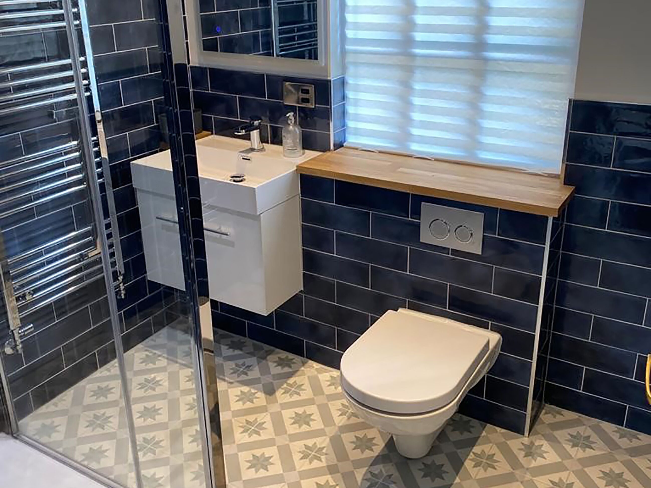 A bathroom with a toilet, sink, and mirror.