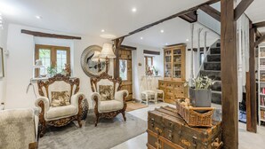 A spacious living room with antique furniture, a large mirror, and a staircase leading to a library. - 6 bedroom accommodation in Highley, near Bridgenorth (Highley, near Bridgenorth)